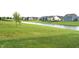 Scenic backyard with a pond view, green lawn, and a row of well-kept houses at 10731 Jimmy Lake Dr, Indianapolis, IN 46239