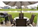 Outdoor patio with a grill and outdoor seating overlooking a serene pond and green space at 10731 Jimmy Lake Dr, Indianapolis, IN 46239