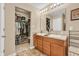 Bathroom with a dual sink vanity, a large mirror, and a walk-in closet with ample storage space at 10731 Jimmy Lake Dr, Indianapolis, IN 46239