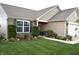 Beautifully landscaped front yard with blooming flowers and lush green lawn; porch with seating area visible at 10731 Jimmy Lake Dr, Indianapolis, IN 46239