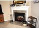 Cozy fireplace with white mantle and tiled surround, accented with decorative items and firewood at 10731 Jimmy Lake Dr, Indianapolis, IN 46239