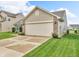Attached two-car garage featuring brick and vinyl siding with a large driveway and landscaped lawn at 10731 Jimmy Lake Dr, Indianapolis, IN 46239
