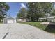 A spacious backyard featuring a detached garage, pergola, and gravel driveway at 1082 Galaxie Dr, Greenwood, IN 46142