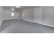 Large basement with neutral gray carpet, multiple lighting fixtures, a window, and easy access to other rooms at 1082 Galaxie Dr, Greenwood, IN 46142