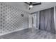 This primary bedroom features an accent wall, gray flooring, ceiling fan, and an ensuite bathroom at 1082 Galaxie Dr, Greenwood, IN 46142