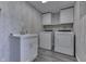 Laundry room features a utility sink with vanity, updated gray flooring, and a modern washer and dryer at 1082 Galaxie Dr, Greenwood, IN 46142
