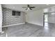 Spacious living room featuring luxury vinyl flooring, accent brick wall and a ceiling fan at 1082 Galaxie Dr, Greenwood, IN 46142