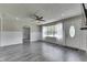 Spacious living room with gray flooring, large bright front window, and decorative brick accent wall with mounted TV at 1082 Galaxie Dr, Greenwood, IN 46142