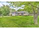 Nice front yard on a home with an attached garage, grass, and mature trees at 1104 Briarwood Dr, Brownsburg, IN 46112