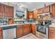 Well-lit kitchen boasts stainless steel appliances, mosaic backsplash, and warm wood cabinetry at 1104 Briarwood Dr, Brownsburg, IN 46112