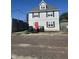 Charming two-story home featuring a striking red door, gray siding, and classic black shutters at 1128 S Pennsylvania St, Indianapolis, IN 46225