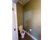 Cozy powder room features wood flooring, a toilet and a fresh coat of green paint at 1128 S Pennsylvania St, Indianapolis, IN 46225