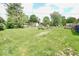 Spacious backyard featuring a fire pit, mature trees, and a lush lawn at 12144 Trolley Rd, Indianapolis, IN 46236