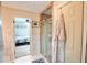 Bathroom featuring glass shower stall and doorway looking into bedroom with blue and white quilt at 12144 Trolley Rd, Indianapolis, IN 46236