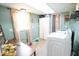 Laundry room with modern washer and dryer, storage cabinets, a window for natural light, and desk space at 12144 Trolley Rd, Indianapolis, IN 46236