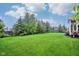 Picture of the large and beautifully landscaped backyard with lush lawn and mature trees at 13145 Roma Bnd, Carmel, IN 46074