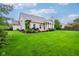 Large grassy backyard with mature trees and well maintained lawn behind a home with an inviting back deck at 13145 Roma Bnd, Carmel, IN 46074