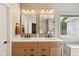 Bathroom showcasing a double vanity with wooden cabinets and a large window at 13145 Roma Bnd, Carmel, IN 46074