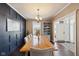 Dining room with long wood table, navy accent wall, and view of foyer at 13145 Roma Bnd, Carmel, IN 46074
