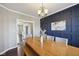 Elegant dining room with a long wooden table, stylish decor, and a view into the kitchen at 13145 Roma Bnd, Carmel, IN 46074