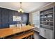 Dining room features a wood table, blue accent wall, and built-in shelving unit with decorative items at 13145 Roma Bnd, Carmel, IN 46074