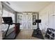 Well-lit exercise room showcasing workout equipment and a decorative white sliding barn door bookcase for storage at 13145 Roma Bnd, Carmel, IN 46074