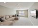 Spacious living room with plush seating, a large window, and a mounted TV at 13145 Roma Bnd, Carmel, IN 46074