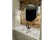 Modern bathroom featuring a sleek vanity, round mirror, decorative lighting, and unique wood accent wall at 1328 N 300 E, Anderson, IN 46012