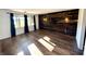 Open living room featuring hardwood floors, a decorative wood accent wall, and modern light fixtures at 1328 N 300 E, Anderson, IN 46012