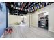 Spacious basement with black ceiling and flags hanging, offering potential for various uses at 14135 Nicholas Dr, Carmel, IN 46074