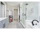 Bright bathroom featuring a glass-enclosed shower, gray tile flooring, and light gray walls at 14135 Nicholas Dr, Carmel, IN 46074