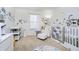 Bright Bedroom featuring dinosaur wall decor, carpet flooring and a crib at 14135 Nicholas Dr, Carmel, IN 46074