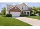 Inviting two-story home with brick and siding, a well-maintained lawn, and an attached garage at 14135 Nicholas Dr, Carmel, IN 46074