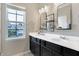 Modern bathroom featuring dual sinks, sleek black cabinets, and a window providing natural light at 15116 Fenchurch Dr, Westfield, IN 46074