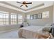 Inviting bedroom featuring tray ceilings, a ceiling fan, and ample natural light from multiple windows at 15116 Fenchurch Dr, Westfield, IN 46074