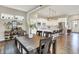 Inviting dining area with a wooden table, adjacent to a modern kitchen with stainless steel appliances and white cabinets at 15116 Fenchurch Dr, Westfield, IN 46074