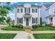 Charming two-story home featuring a white brick facade, black shutters, and a beautifully landscaped front yard at 15116 Fenchurch Dr, Westfield, IN 46074
