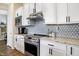 This stylish kitchen features stainless steel appliances, white cabinets, hexagon backsplash, and sleek countertops for a modern look at 15116 Fenchurch Dr, Westfield, IN 46074