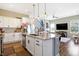 Well-lit kitchen featuring an island with a sink, stainless steel appliances, and a seamless open concept to the living room at 15116 Fenchurch Dr, Westfield, IN 46074