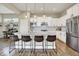 Modern kitchen boasts white cabinetry, granite counters, stainless appliances, and stylish pendant lighting over the island at 15116 Fenchurch Dr, Westfield, IN 46074