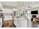Bright kitchen with white cabinets, stainless steel appliances, and a granite island adjacent to the living room at 15116 Fenchurch Dr, Westfield, IN 46074