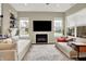 Spacious living room with a modern fireplace, large windows, and comfortable couches providing ample seating at 15116 Fenchurch Dr, Westfield, IN 46074