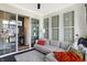 Bright sunroom with a cozy gray sofa, plush rug, and sliding glass doors leading to other rooms at 15116 Fenchurch Dr, Westfield, IN 46074