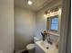 Stylish half-bathroom with modern vanity, decorative mirror, and contemporary lighting at 1718 South Dr, Columbus, IN 47203