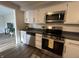 Well-equipped kitchen with stainless steel appliances, white cabinetry, and modern finishes at 1718 South Dr, Columbus, IN 47203