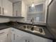 Close-up of kitchen sink with stylish faucet, white cabinets, and bright lighting at 1718 South Dr, Columbus, IN 47203