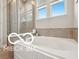 Elegant soaking tub with tiled walls and bright natural light at 19175 English Lake Ln, Noblesville, IN 46062