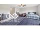 Spacious bedroom featuring a bed with a blue and gray comforter, lounge chair, and dresser with storage at 19175 English Lake Ln, Noblesville, IN 46062