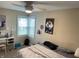 Well-lit bedroom with a ceiling fan, a desk, and a window that allows natural light to illuminate the room at 1931 E 68Th St, Indianapolis, IN 46220