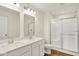 Modern bathroom featuring double sinks, quartz countertops, and a glass-enclosed shower with a seat at 19584 Atwater Ave, Sheridan, IN 46069
